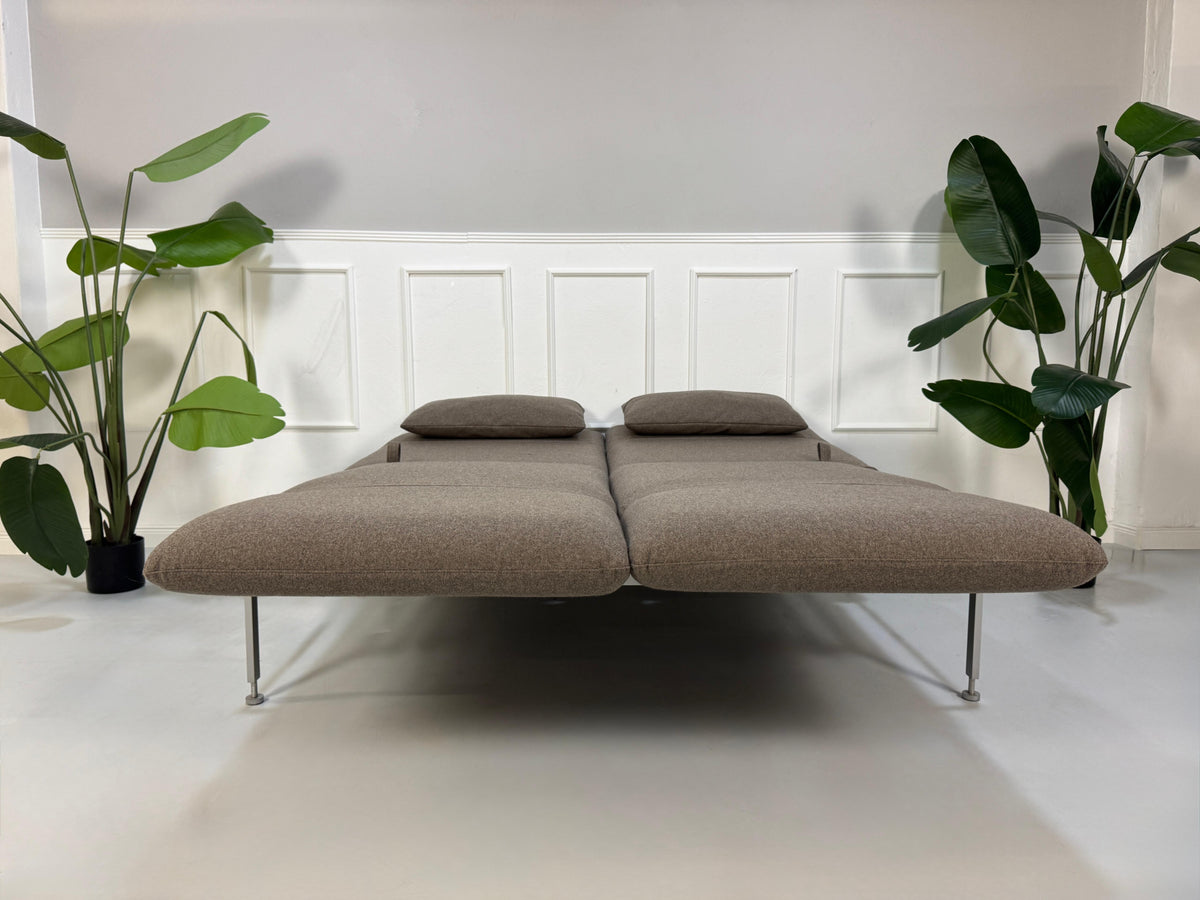 Gebrauchtes braunes Brühl Roro Medium Designer Stoff Sofa vor einer Wand, stilvoll und modern eingerichtet.