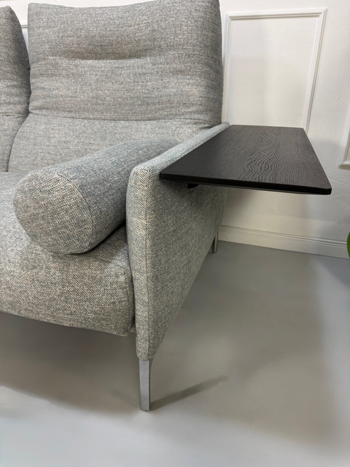 Gebrauchtes graues Stoffsofa mit einem Hocker von COR Modell Avalanche vor einer modernen Wand.