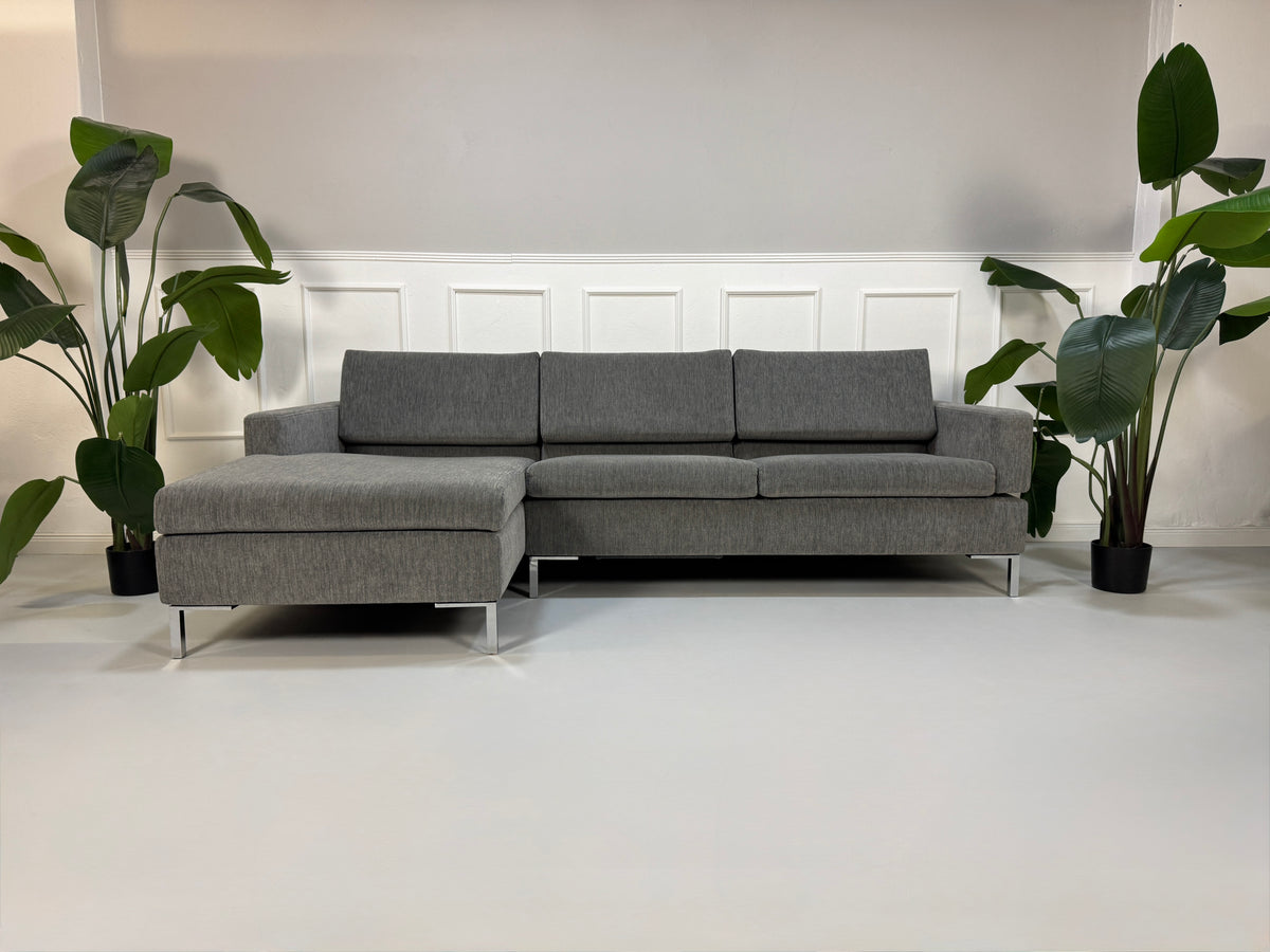 Gebrauchtes Brühl Tomo Designer Stoff Sofa in der Farbe Grau vor einer Wand, stilvoll und modern eingerichtet.
