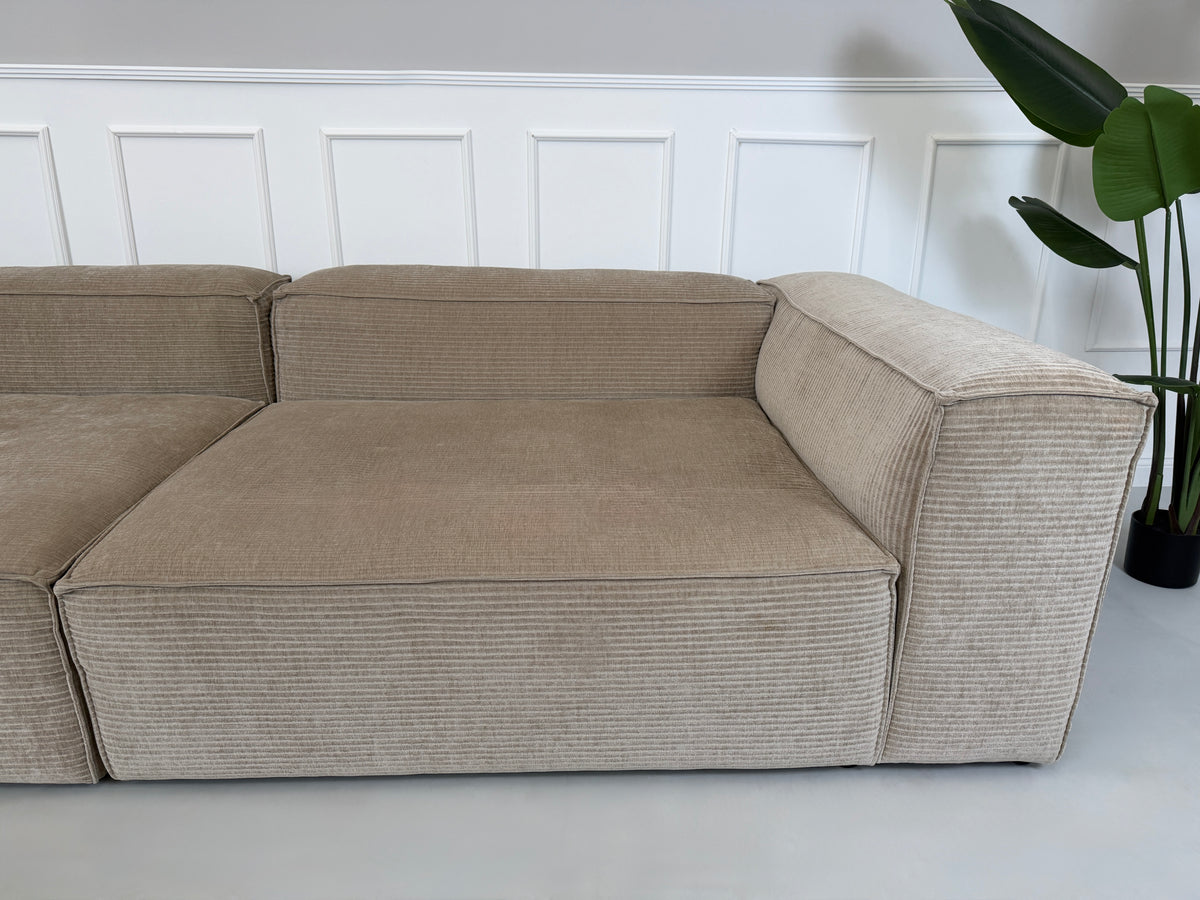 Gebrauchtes beigees Bolia Cosima Designer Stoff Sofa vor einer Wand, stilvoll und modern eingerichtet.