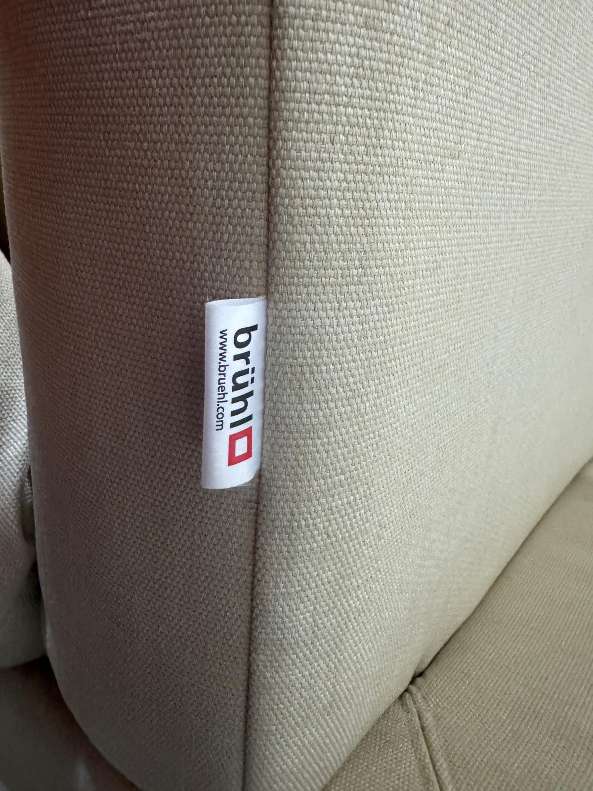 Gebrauchtes beigees Brühl Moule Designer Stoff Sofa vor einer Wand, stilvoll und modern eingerichtet.