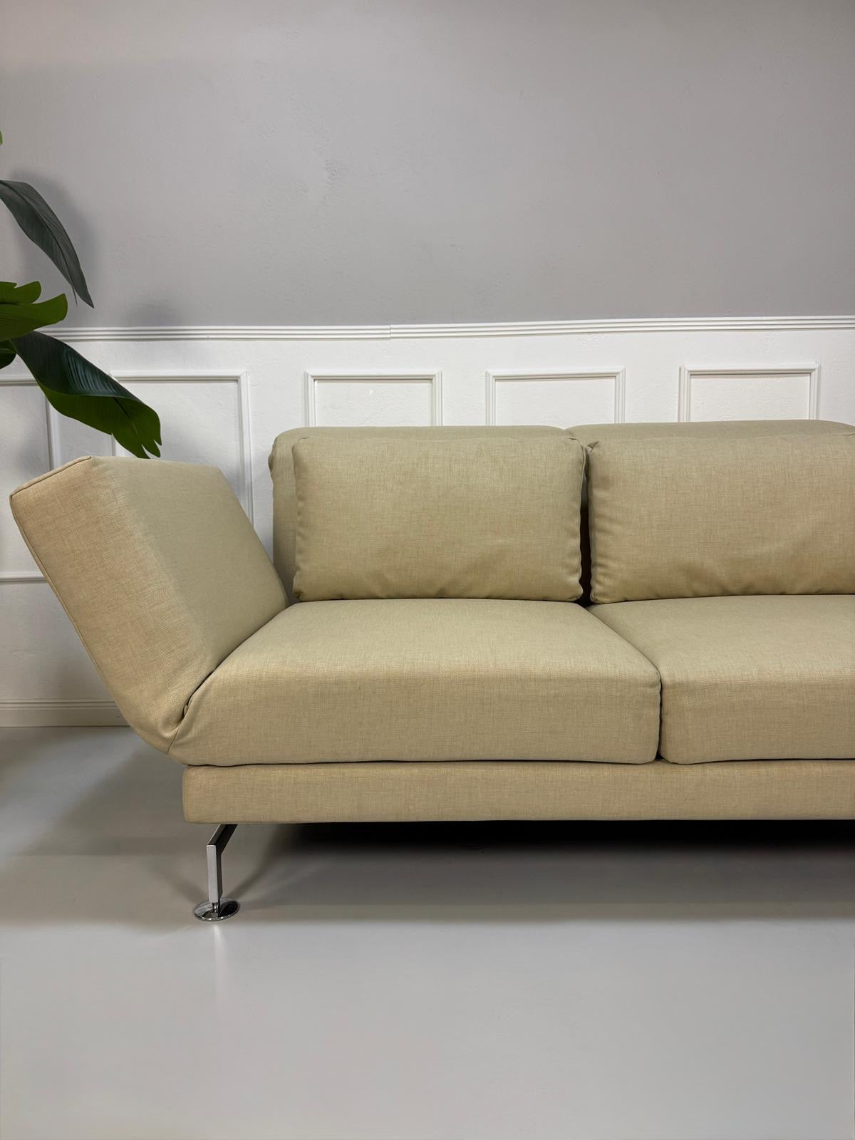 Gebrauchtes beigees Brühl Moule Designer Stoff Sofa vor einer Wand, stilvoll und modern eingerichtet.