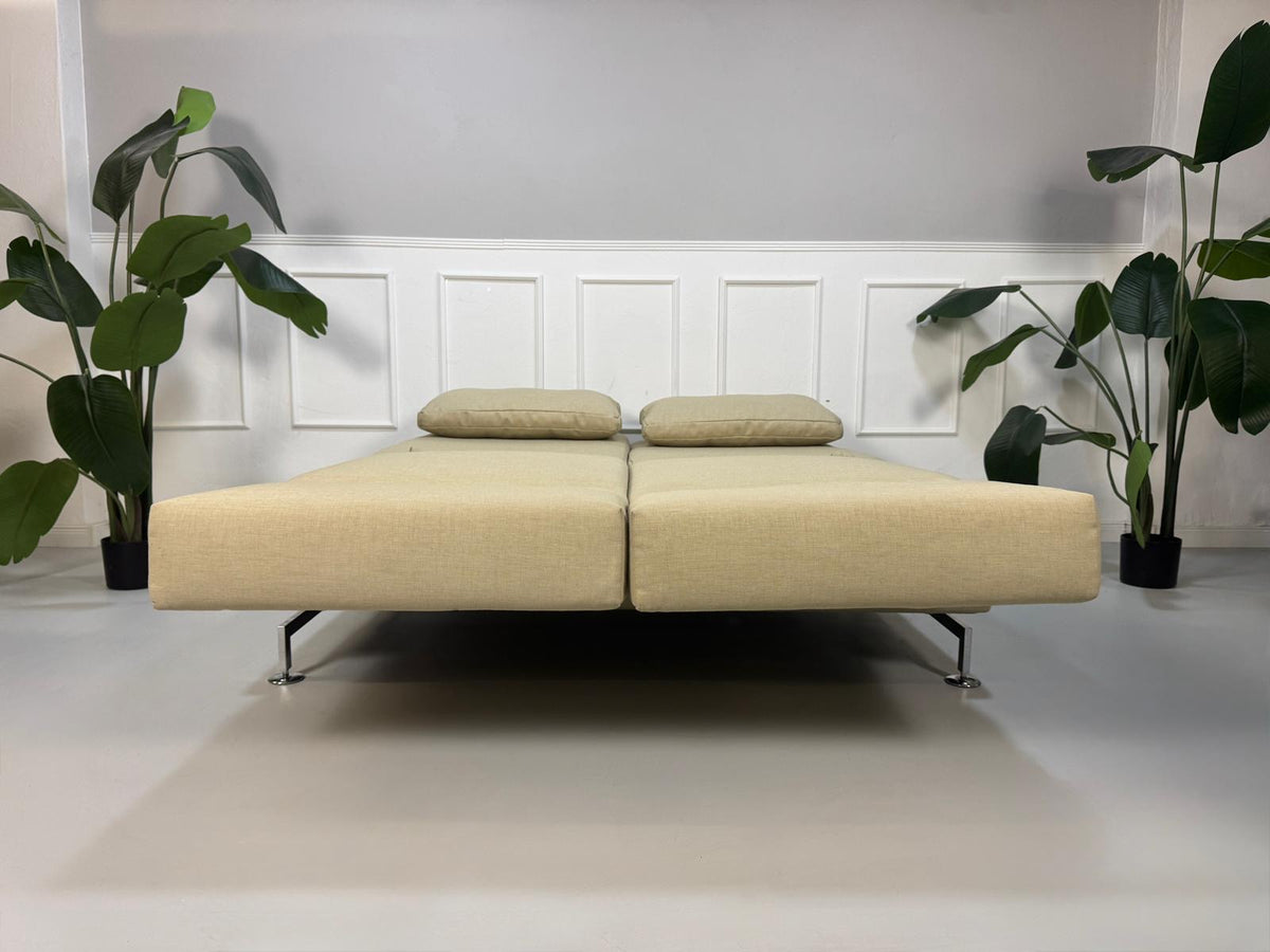 Gebrauchtes beigees Brühl Moule Designer Stoff Sofa vor einer Wand, stilvoll und modern eingerichtet.