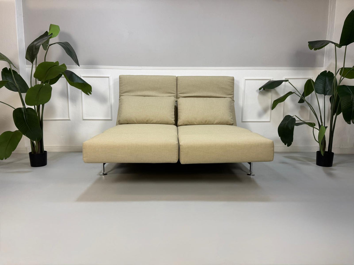 Gebrauchtes beigees Brühl Moule Designer Stoff Sofa vor einer Wand, stilvoll und modern eingerichtet.