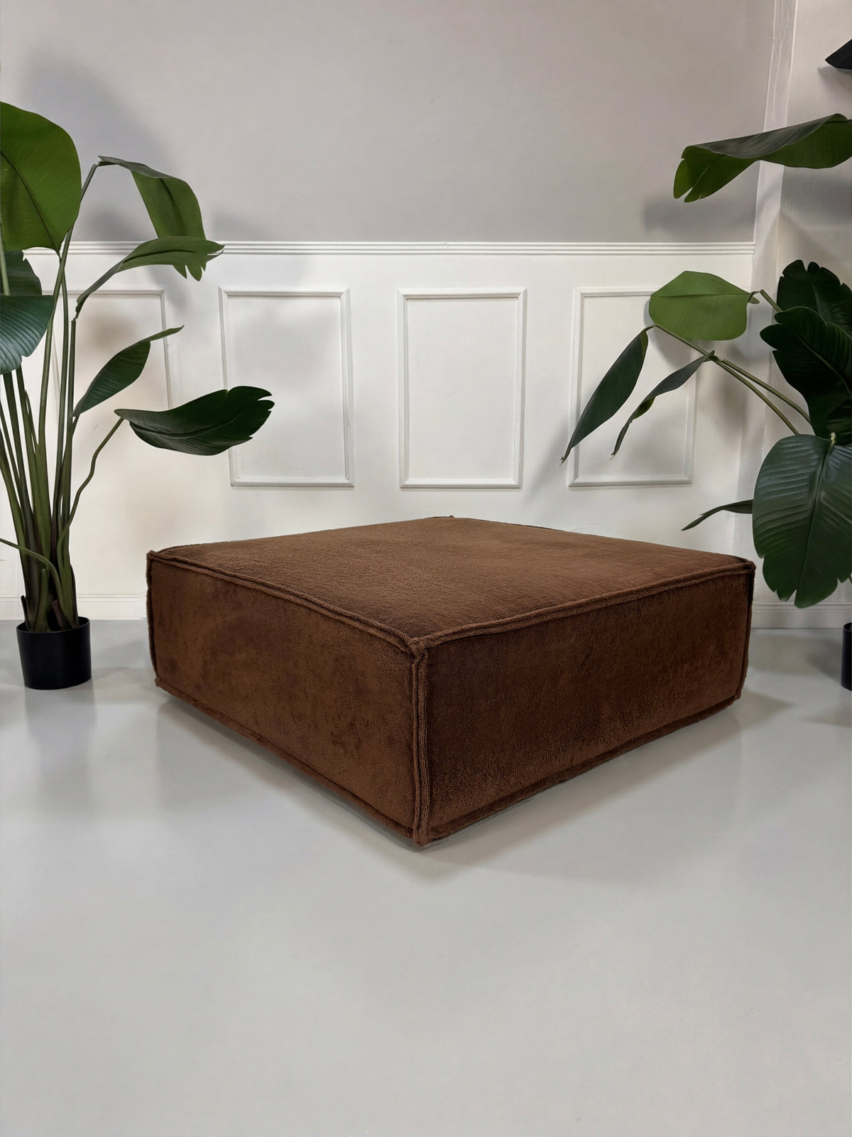 Gebrauchtes braunes COR Trio Designer Stoff Sofa vor einer Wand, stilvoll und modern eingerichtet.