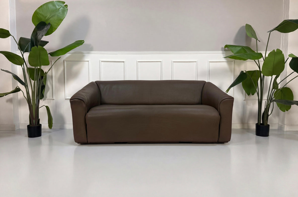 Gebrauchtes braunes De Sede DS 47 Designer Leder Sofa vor einer Wand, stilvoll und modern eingerichtet.