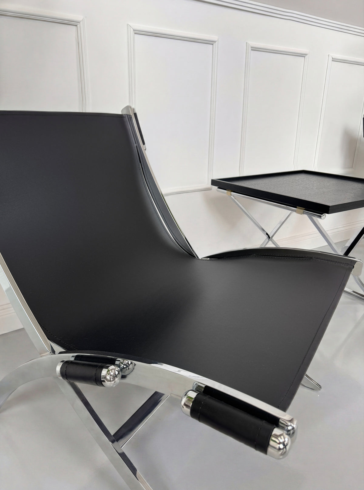 Gebrauchter schwarzer Flexform Timeless Chair Designer Leder Stuhl vor einer Wand, stilvoll und modern eingerichtet.