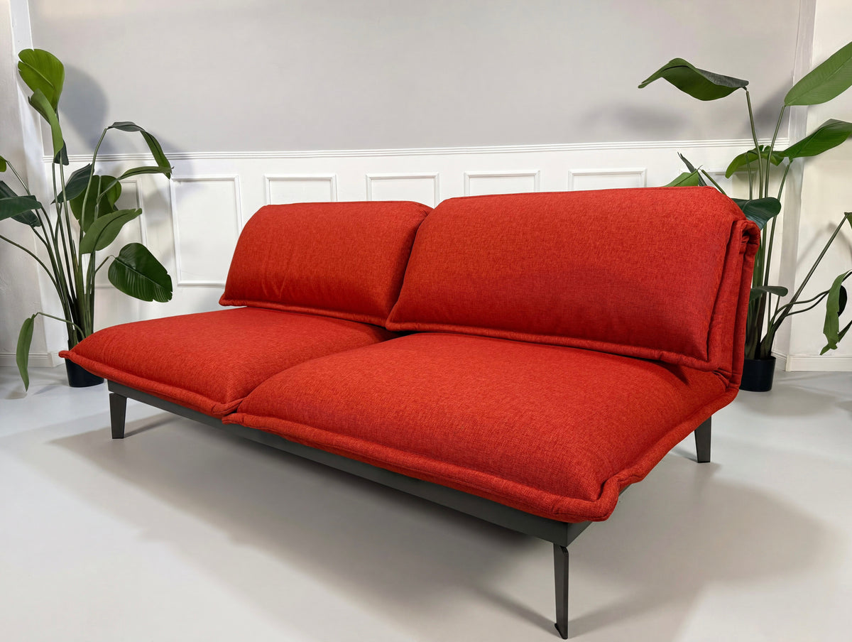 Gebrauchtes Rolf Benz Nova Designer Stoff Sofa vor einer Wand, stilvoll und modern eingerichtet.
