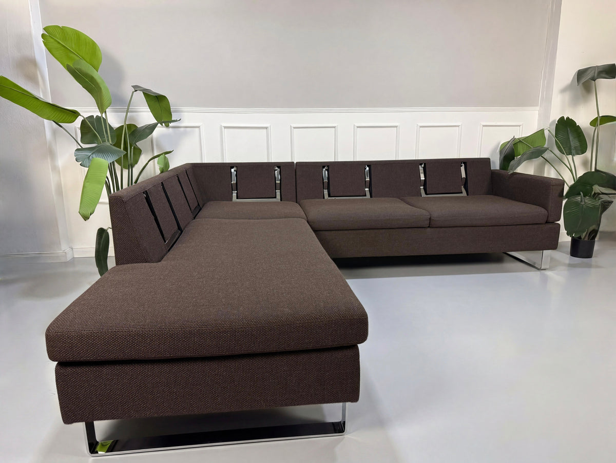 Gebrauchtes braunes Brühl Alba Designer Stoff Ecksofa vor einer Wand, stilvoll und modern eingerichtet.