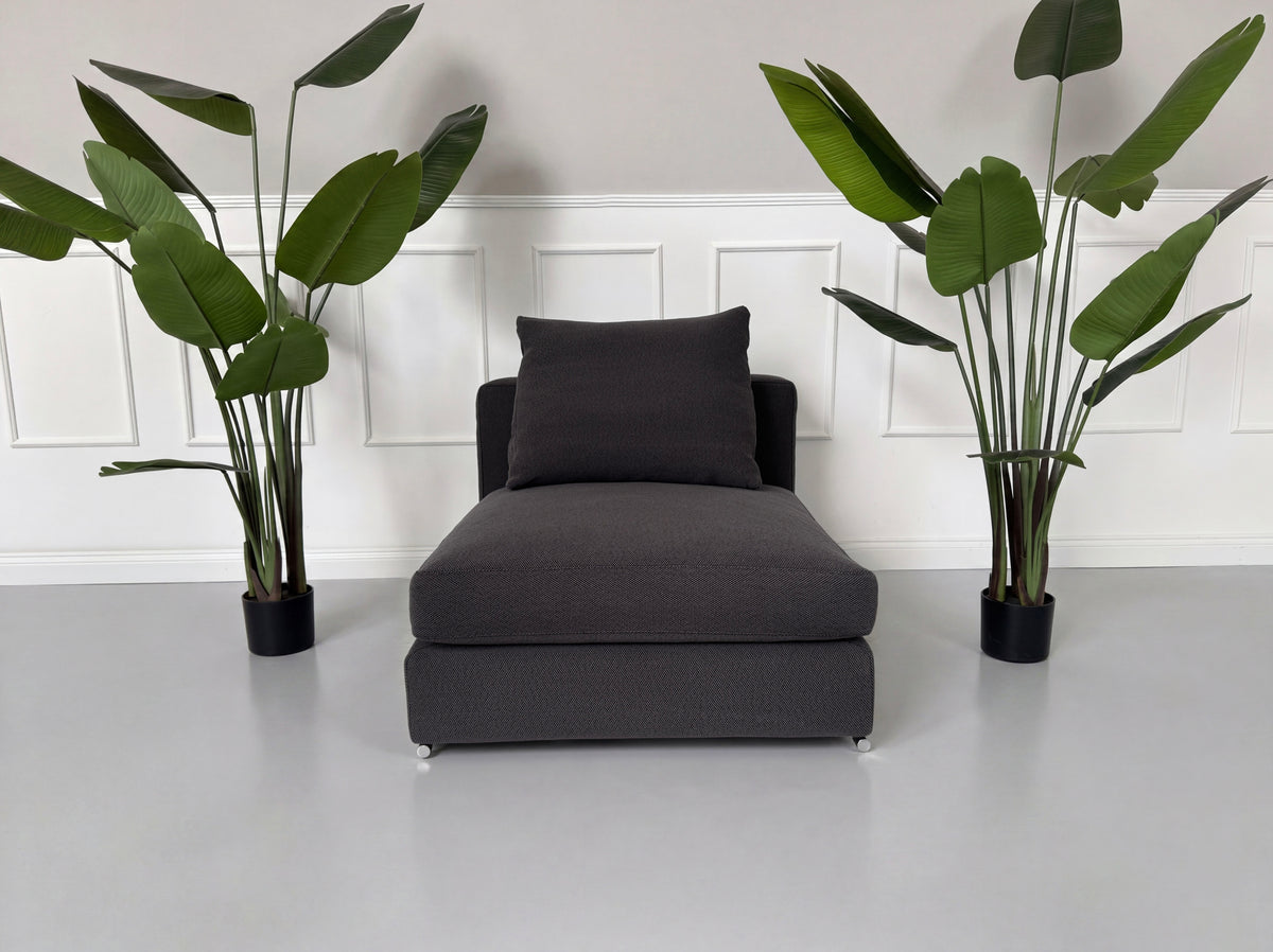 Gebrauchter grauer Minotti Jagger Designer Stoff Sessel vor einer Wand, stilvoll und modern eingerichtet.