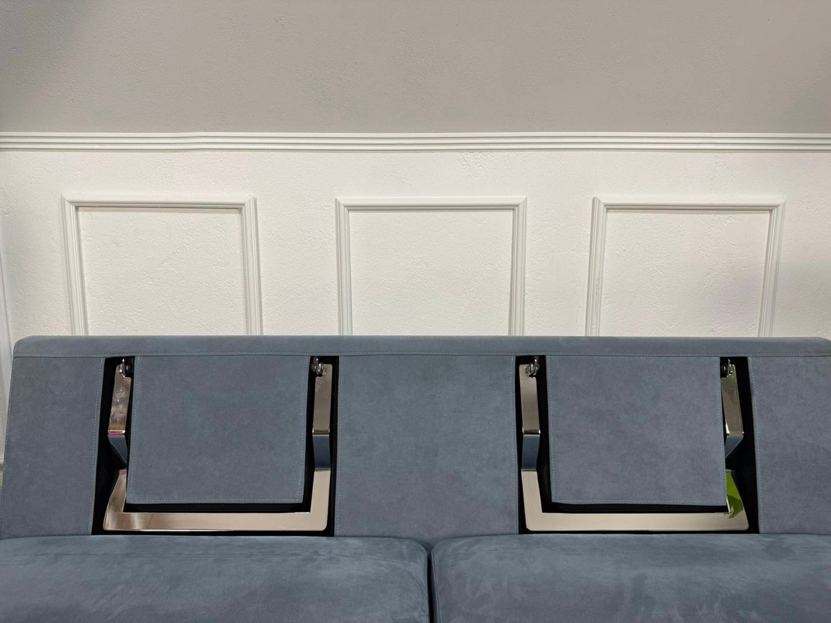 Gebrauchtes blaues Brühl Alba Designer Stoff Sofa vor einer Wand, stilvoll und modern eingerichtet.