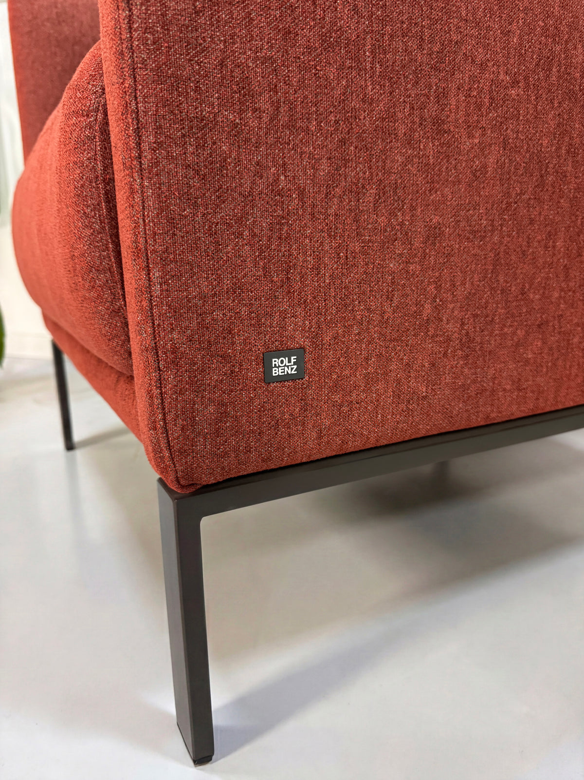 Gebrauchtes rotes Rolf Benz Cara Designer Stoff Sofa vor einer Wand, stilvoll und modern eingerichtet.