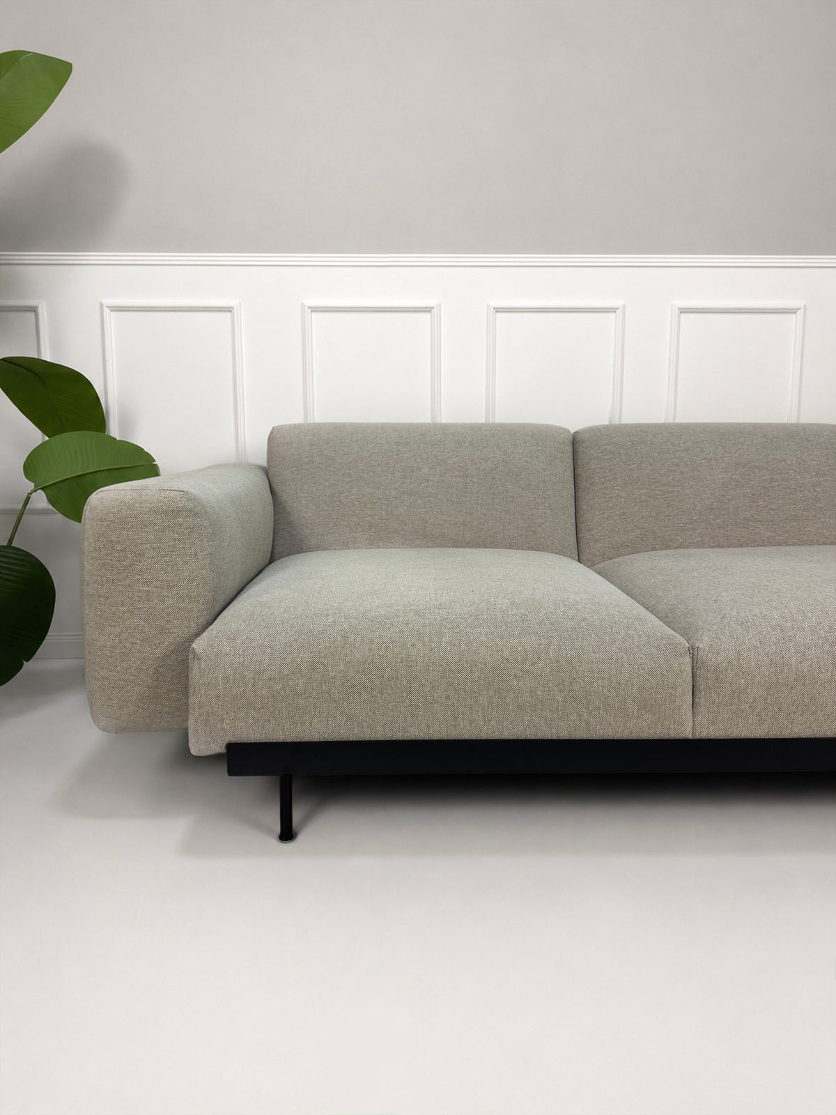 Gebrauchtes graues Muuto In Situ Designer Stoff Sofa vor einer Wand, stilvoll und modern eingerichtet.