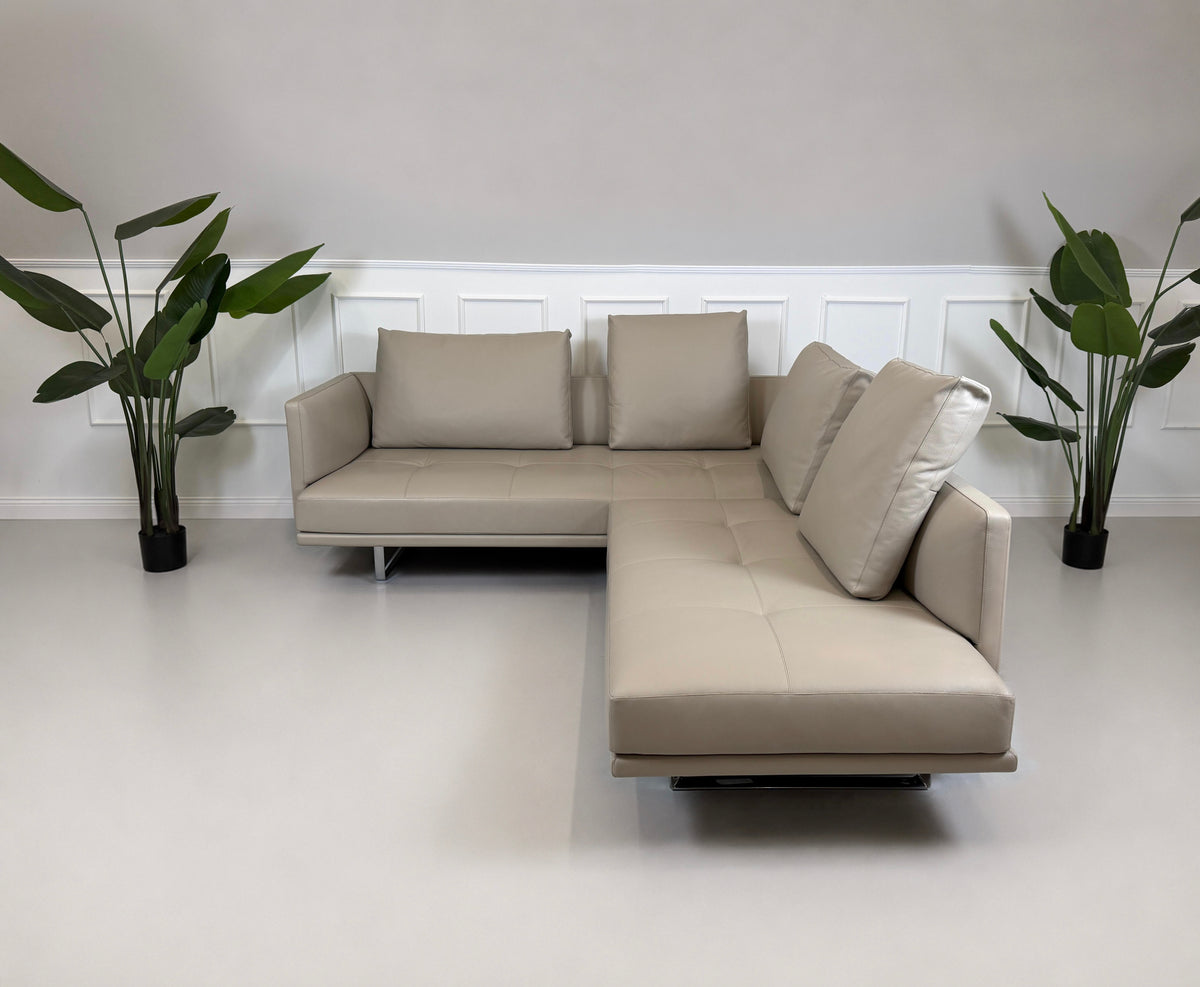 Gebrauchtes graues Walter Knoll Prime Time Designer Leder Ecksofa vor einer Wand, stilvoll und modern eingerichtet.