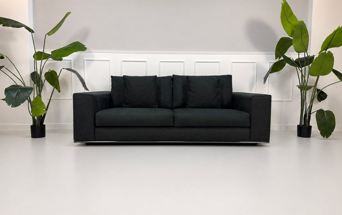 Gebrauchtes graues Minotti Hamilton Designer Stoff Sofa vor einer Wand, stilvoll und modern eingerichtet.