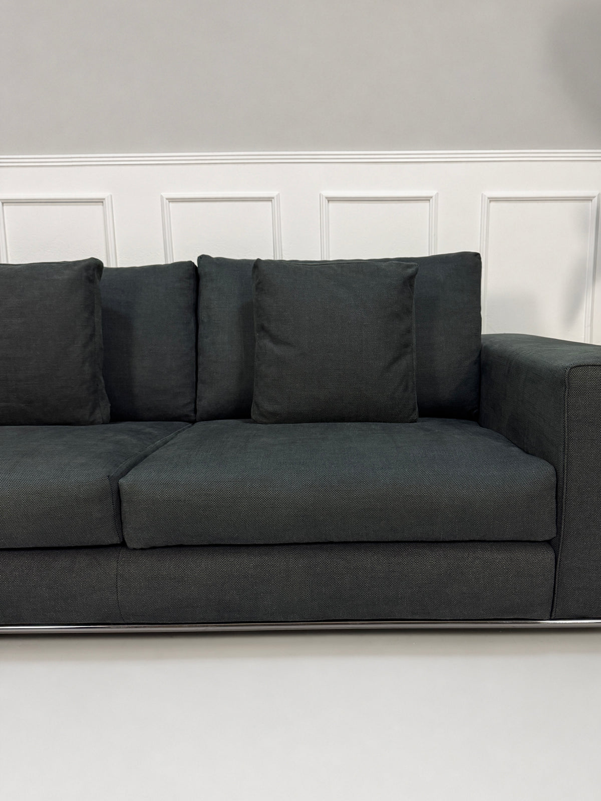 Gebrauchtes graues Minotti Hamilton Designer Stoff Sofa vor einer Wand, stilvoll und modern eingerichtet.