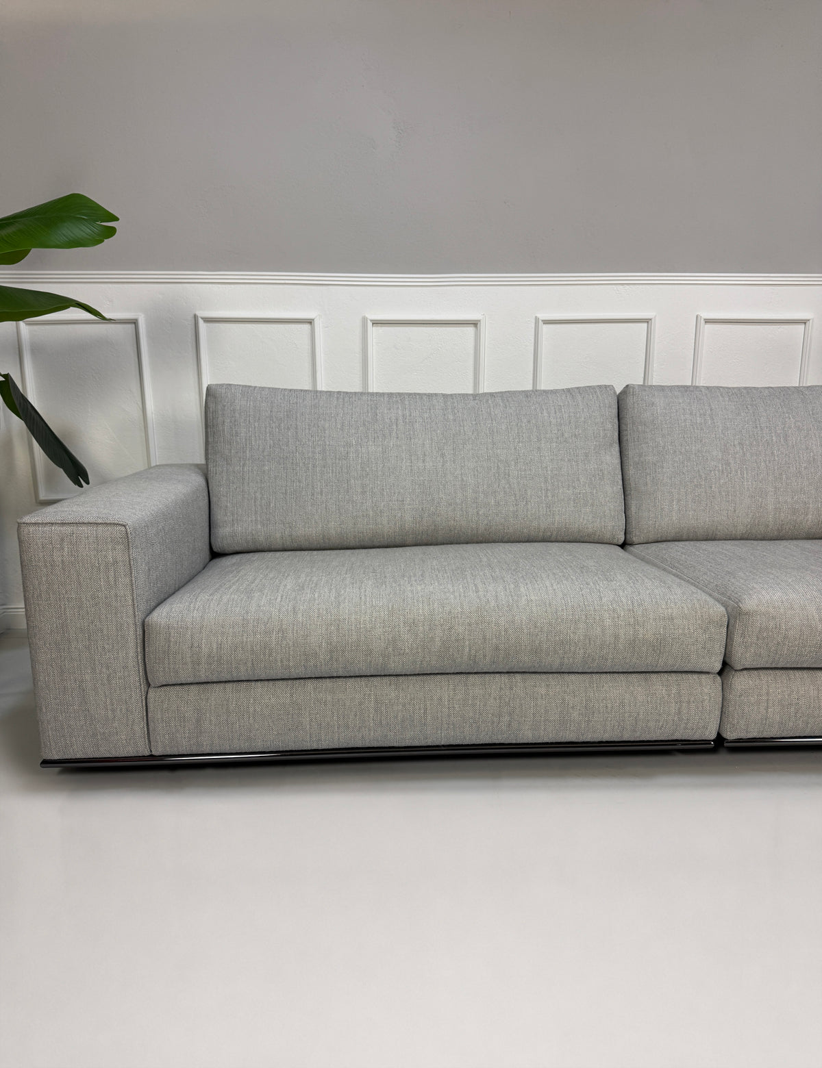 Gebrauchtes graues Minotti Hamilton Designer Stoff Sofa vor einer Wand, stilvoll und modern eingerichtet.