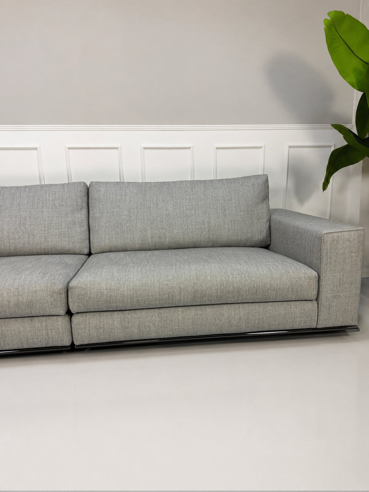Gebrauchtes graues Minotti Hamilton Designer Stoff Sofa vor einer Wand, stilvoll und modern eingerichtet.