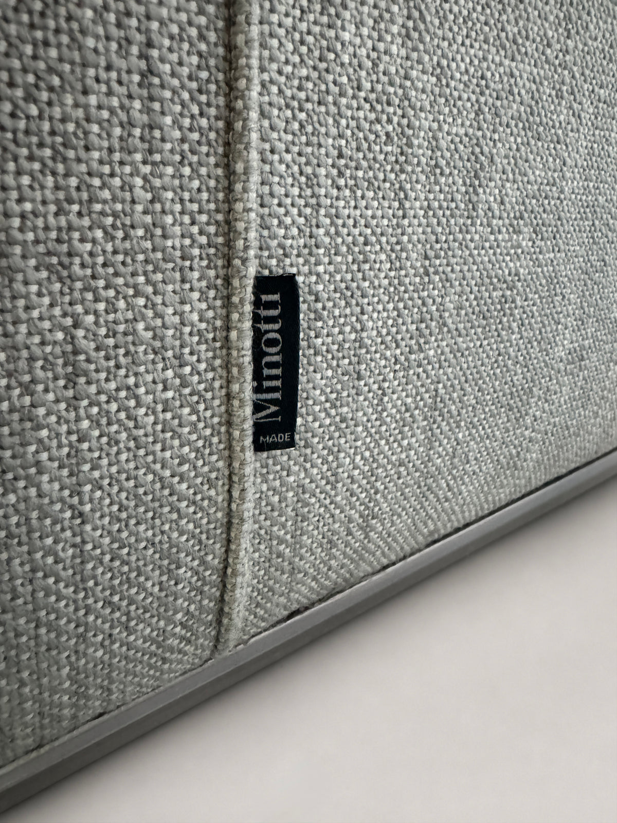 Gebrauchtes graues Minotti Hamilton Designer Stoff Sofa vor einer Wand, stilvoll und modern eingerichtet.