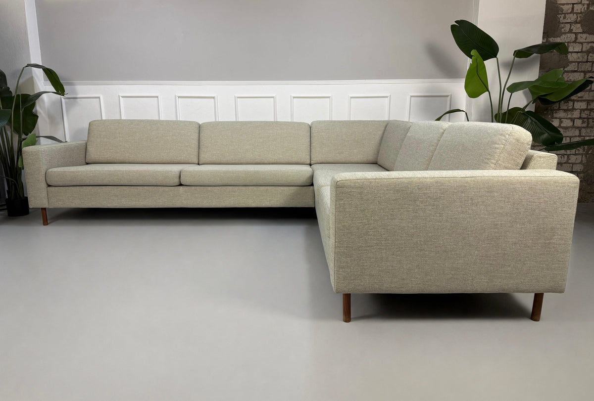 Gebrauchtes beiges Bolia Scandinavia 6 Sitzer Designer Stoff Sofa vor einer Wand, stilvoll und modern eingerichtet.