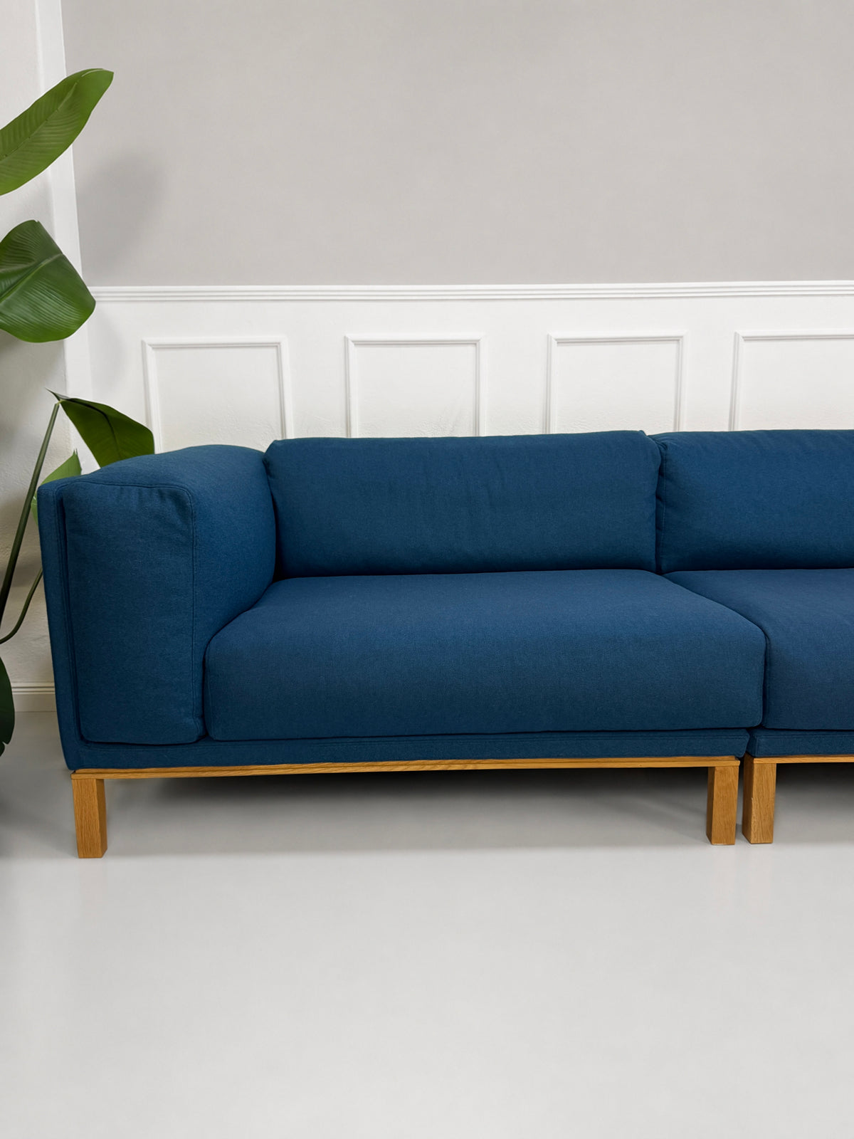 Gebrauchtes blaues Bolia Cosy Designer Stoff Sofa vor einer Wand, stilvoll und modern eingerichtet.