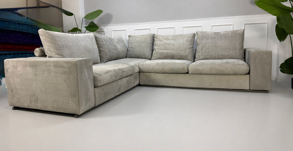 Gebrauchtes graues Flexform Groundpiece Designer Stoff Sofa vor einer Wand, stilvoll und modern eingerichtet.