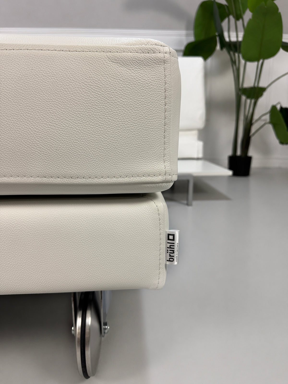 Gebrauchtes weißes Brühl Fourtwo Designer Leder Ecksofa vor einer Wand, stilvoll und modern eingerichtet.