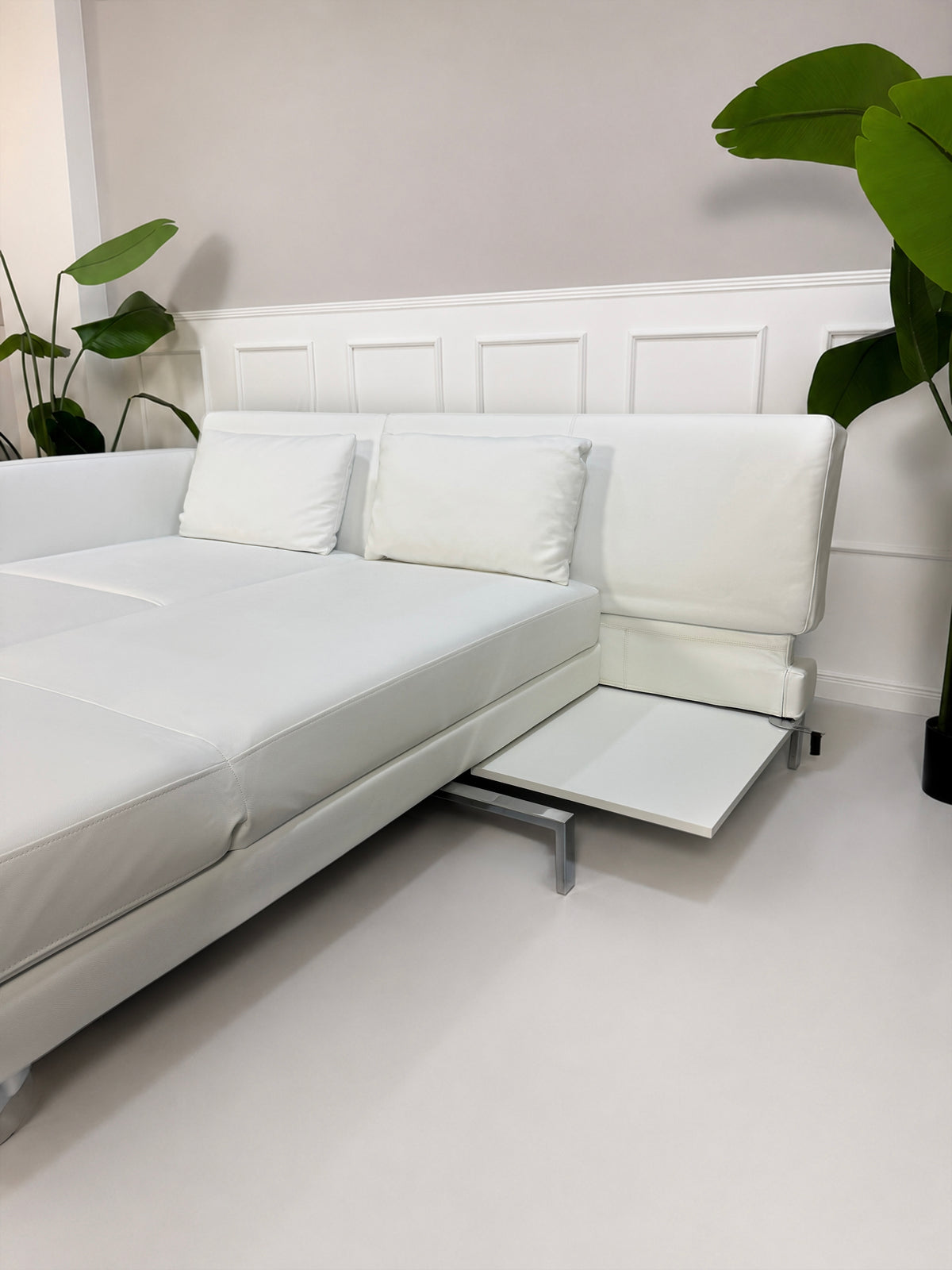 Gebrauchtes weißes Brühl Fourtwo Designer Leder Ecksofa vor einer Wand, stilvoll und modern eingerichtet.