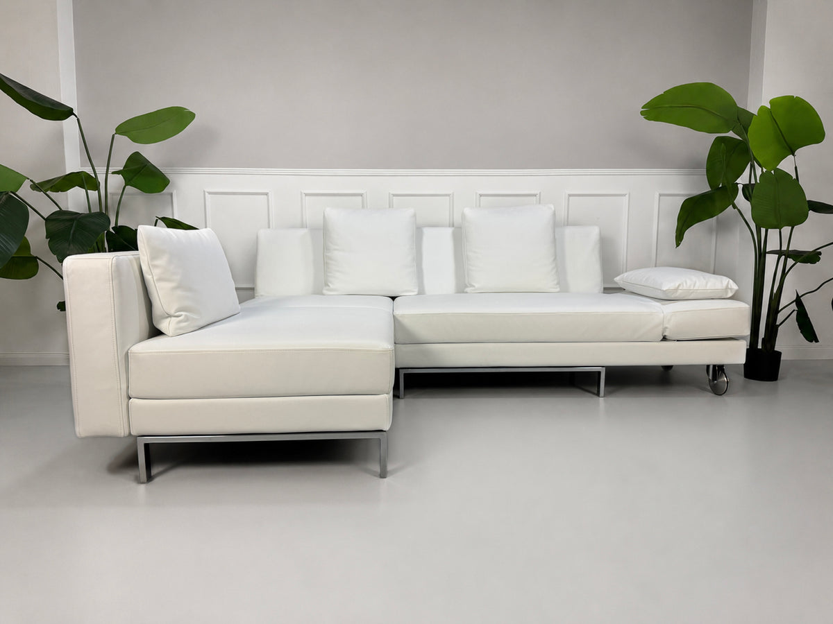 Gebrauchtes weißes Brühl Fourtwo Designer Leder Ecksofa vor einer Wand, stilvoll und modern eingerichtet.