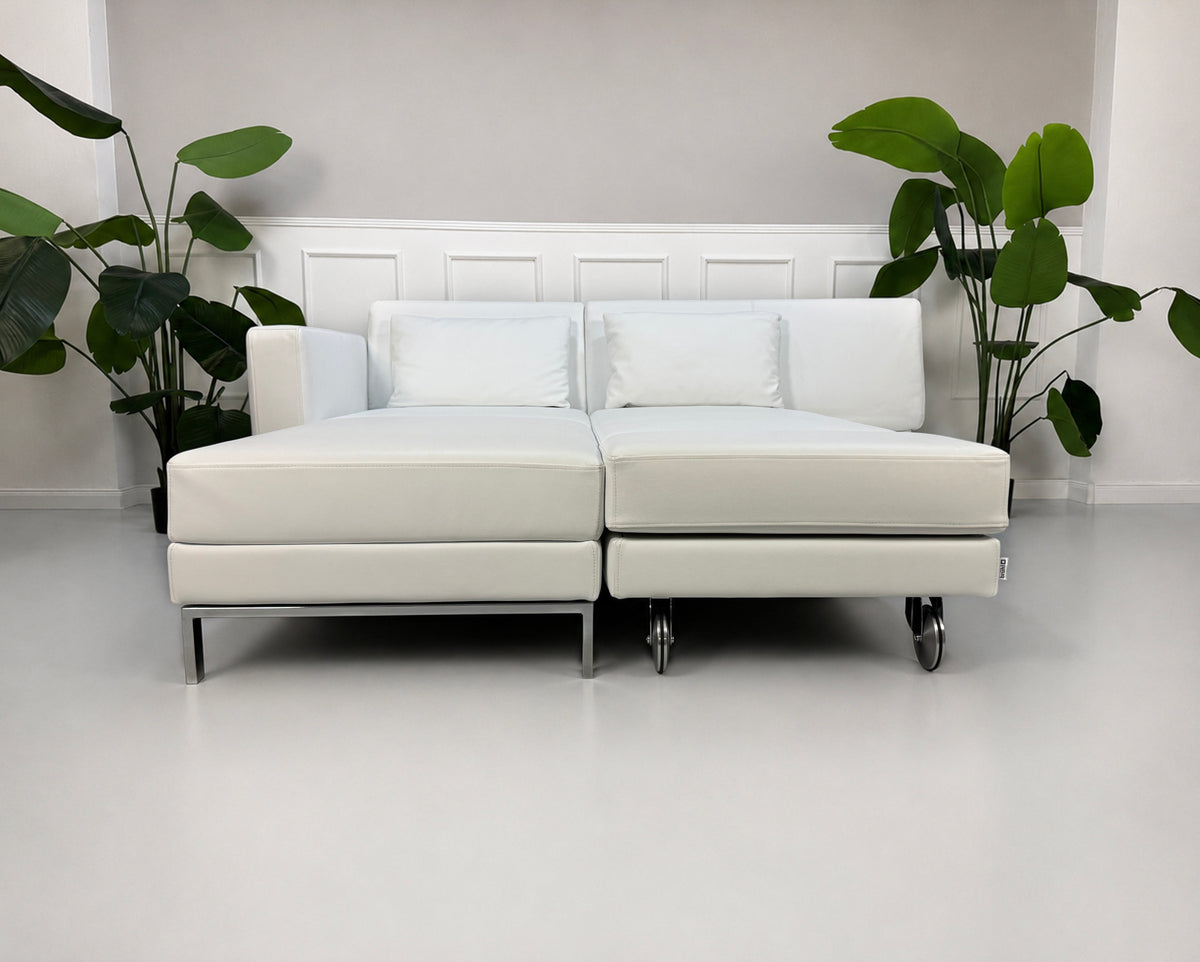 Gebrauchtes weißes Brühl Fourtwo Designer Leder Ecksofa vor einer Wand, stilvoll und modern eingerichtet.