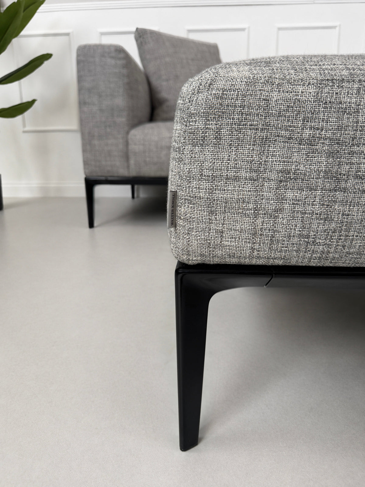 Gebrauchtes graues Walter Knoll Jaan Living Designer Stoff Sofa mit Hocker vor einer Wand, stilvoll und modern eingerichtet.