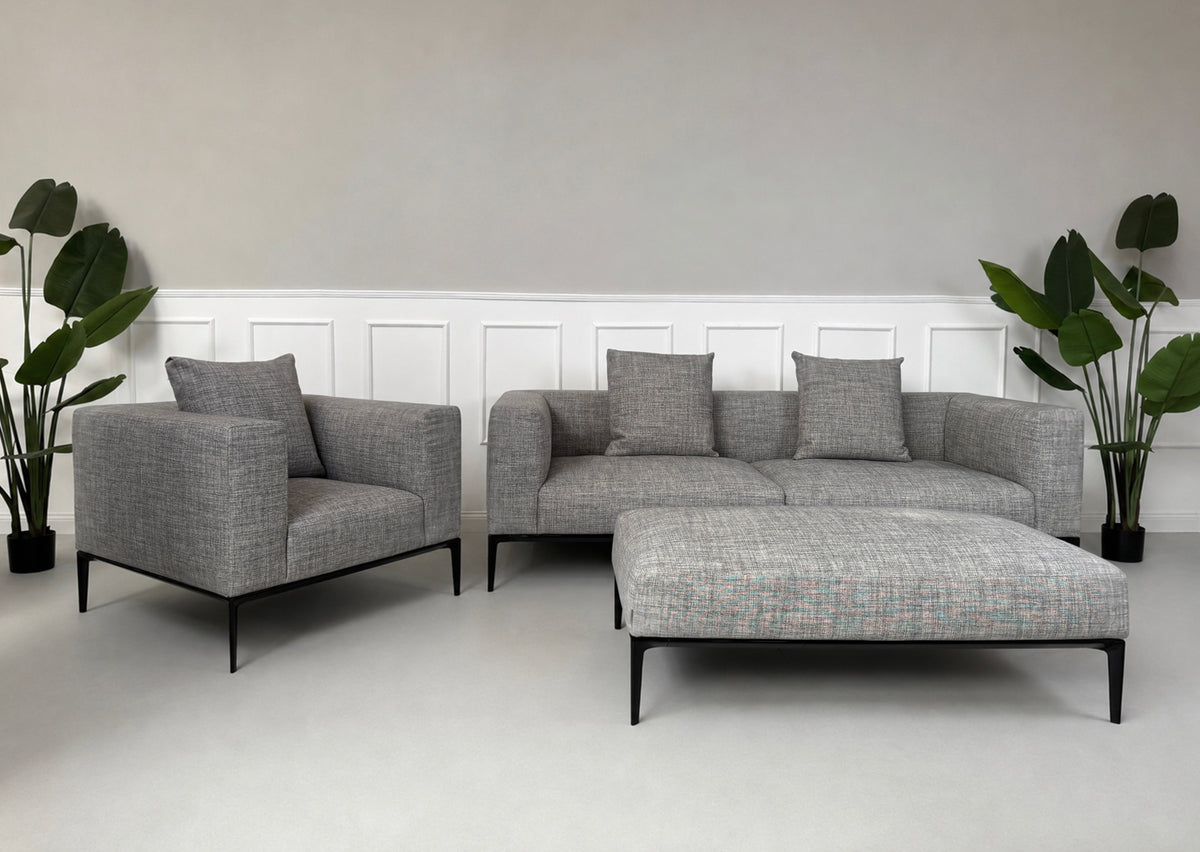 Gebrauchtes graues Walter Knoll Jaan Living Designer Stoff Sofa mit Hocker vor einer Wand, stilvoll und modern eingerichtet.
