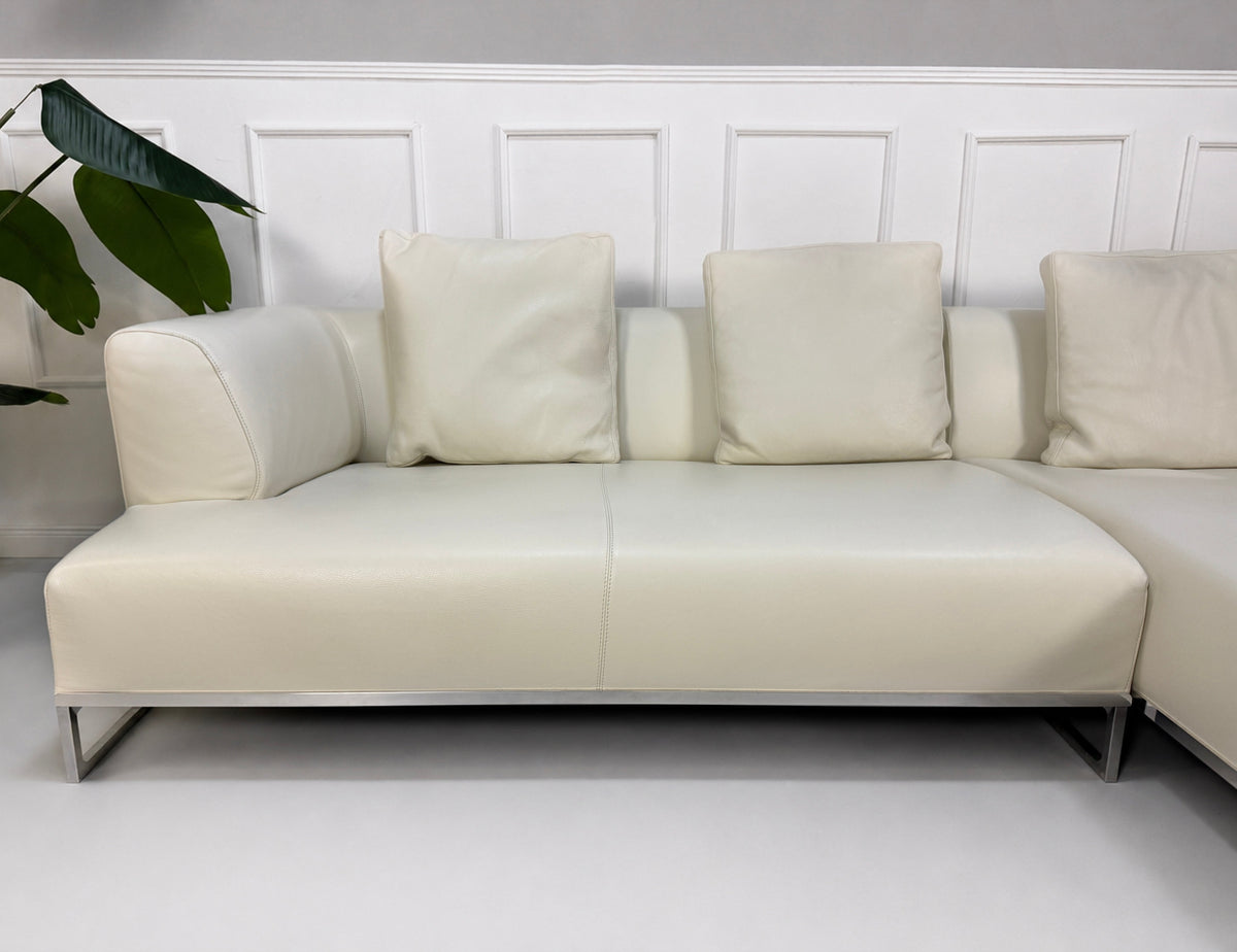 Gebrauchtes weißes B&B Italia Solo Designer Leder Sofa vor einer Wand, stilvoll und modern eingerichtet.