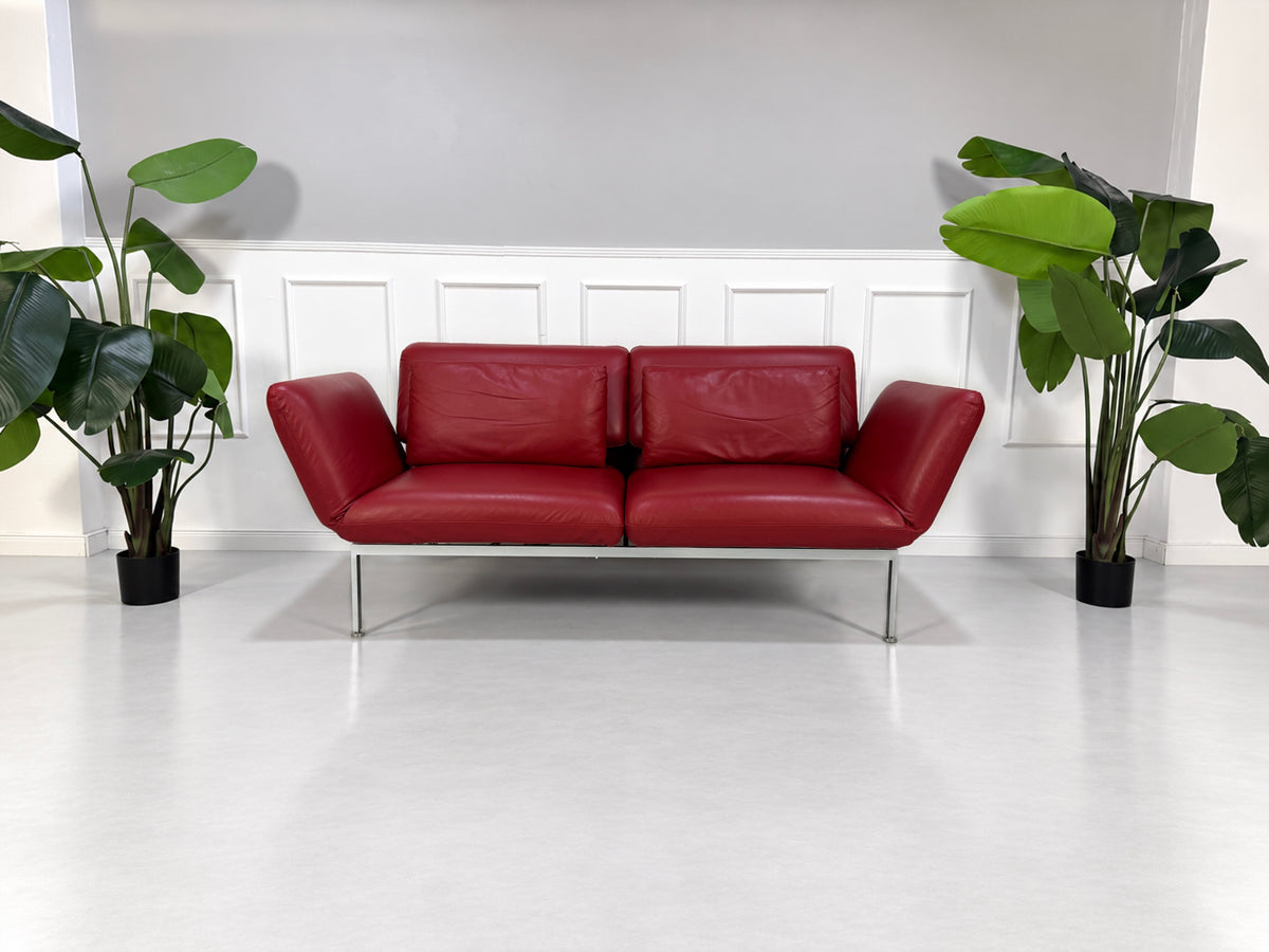 Gebrauchtes rotes Brühl Roro Medium Designer Leder Sofa vor einer Wand, stilvoll und modern eingerichtet.