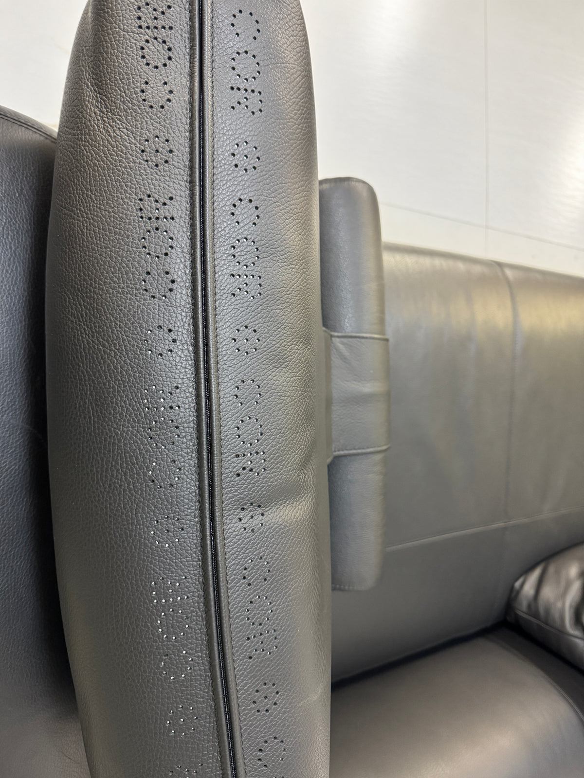 Gebrauchtes schwarzes COR Mell Designer Leder Sofa vor einer Wand, stilvoll und modern eingerichtet.
