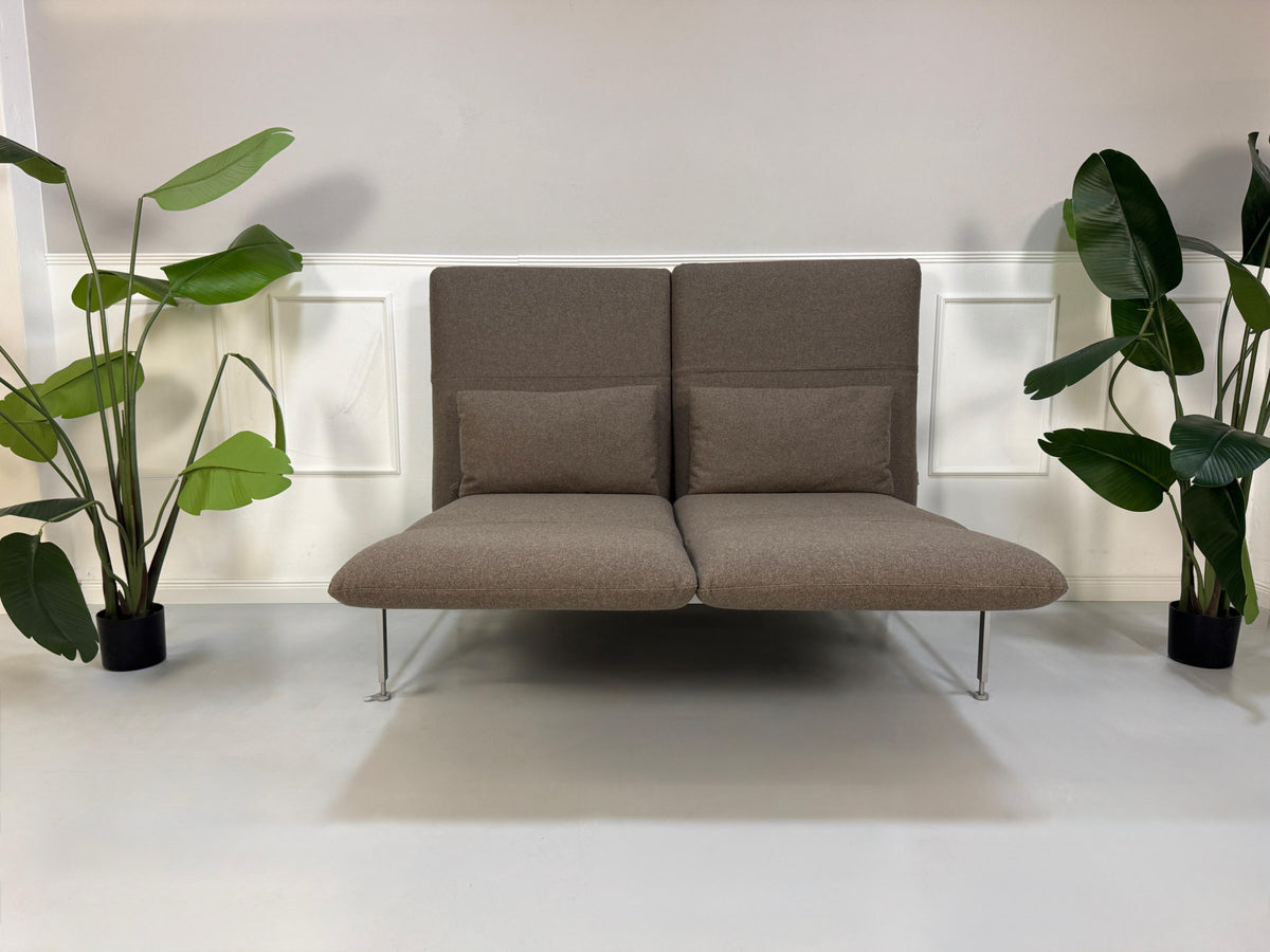 Gebrauchtes braunes Brühl Roro Medium Designer Stoff Sofa vor einer Wand, stilvoll und modern eingerichtet.
