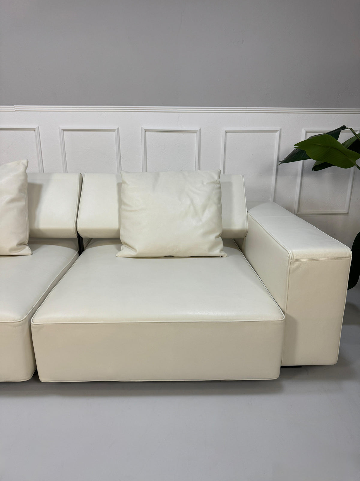 Gebrauchtes weißes B&B Italia Andy Designer Leder Sofa vor einer Wand, stilvoll und modern eingerichtet.