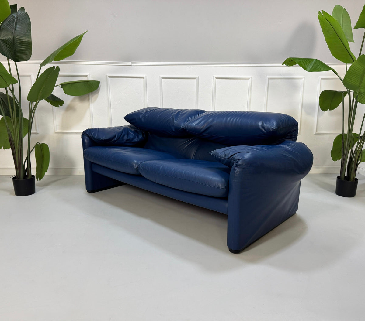 Gebrauchtes blaues Cassina Maralunga Designer Leder Sofa vor einer Wand, stilvoll und modern eingerichtet.