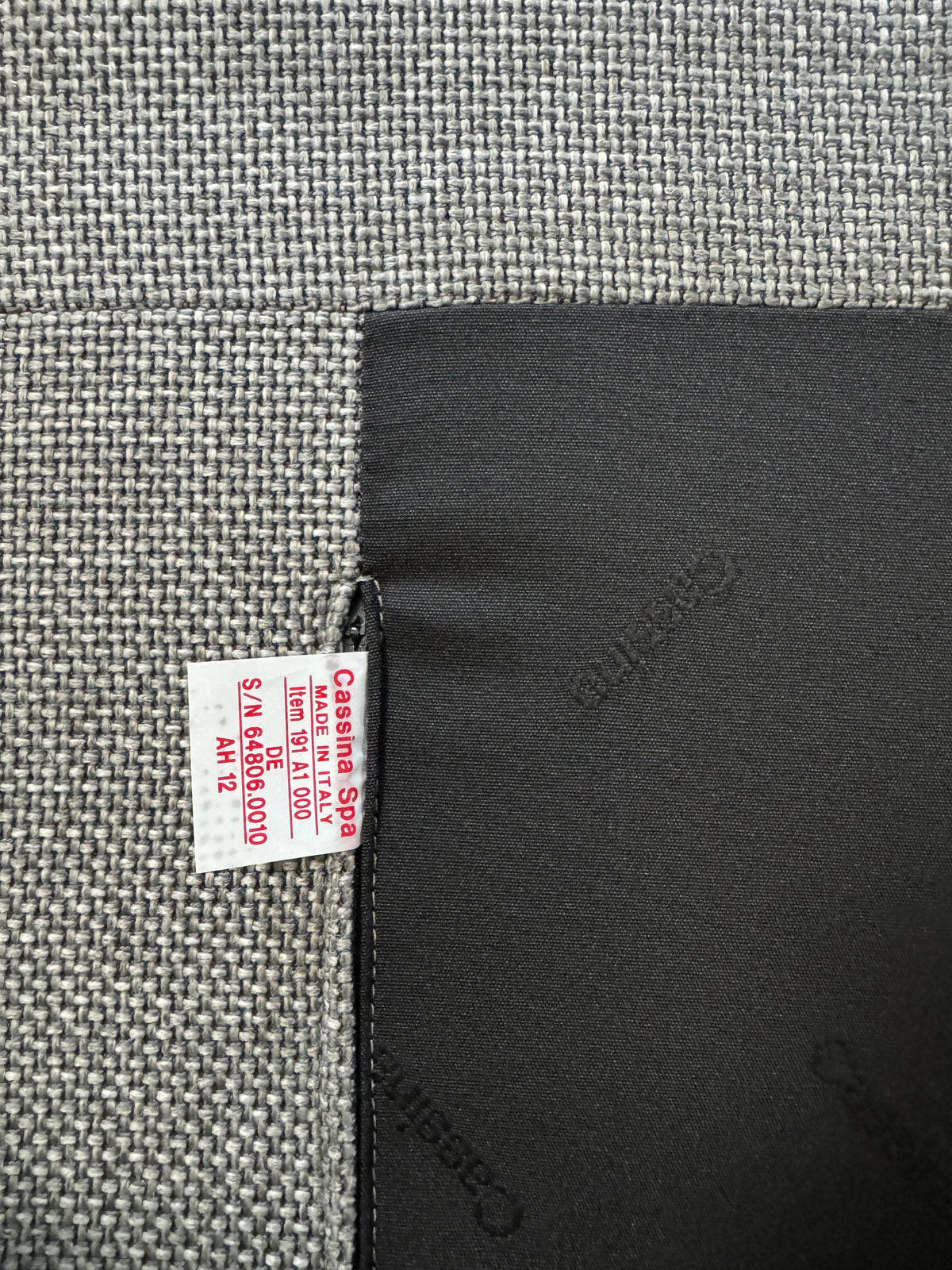 Gebrauchtes graues Cassina Moov Zweisitzer Designer Stoff Sofa vor einer Wand, stilvoll und modern eingerichtet.
