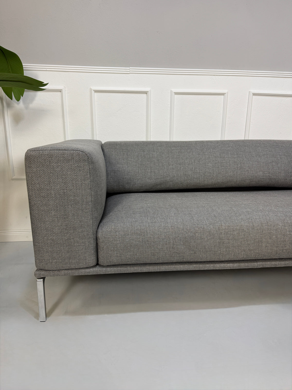 Gebrauchtes graues Cassina Moov Zweisitzer Designer Stoff Sofa vor einer Wand, stilvoll und modern eingerichtet.
