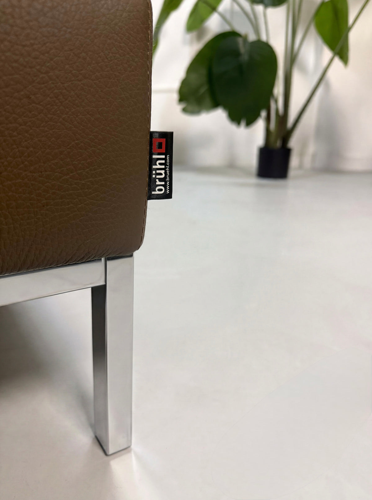 Gebrauchtes braunes Brühl Tomo Designer Leder Ecksofa vor einer Wand, stilvoll und modern eingerichtet.