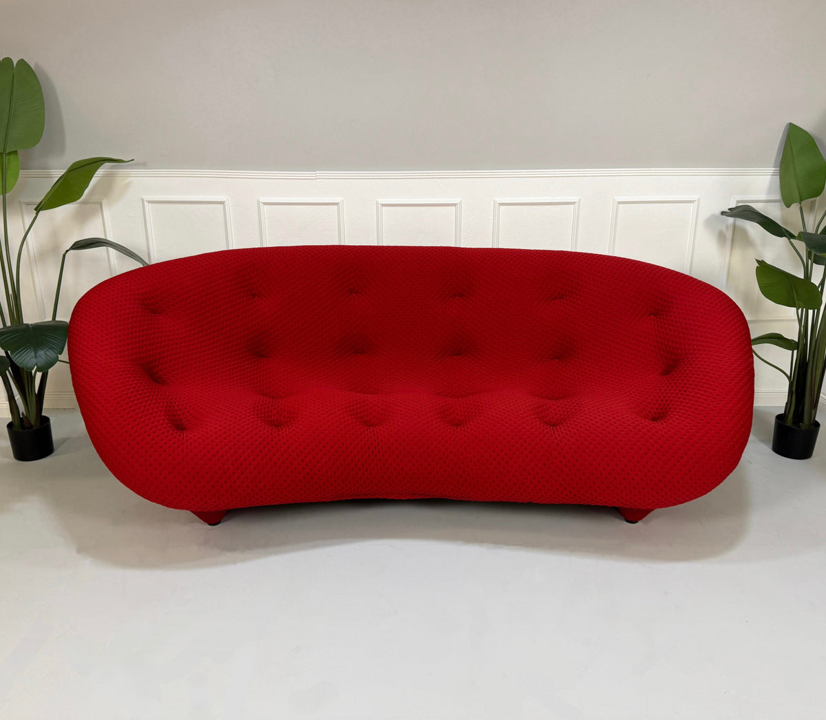 Gebrauchtes rotes Ligne Roset Ploum Designer Stoff Sofa vor einer Wand, stilvoll und modern eingerichtet.