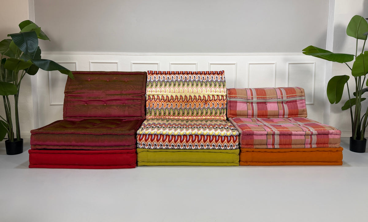 Gebrauchtes buntes Roche Bobois Mah Jong Designer Stoff Sofa vor einer Wand, stilvoll und modern eingerichtet.