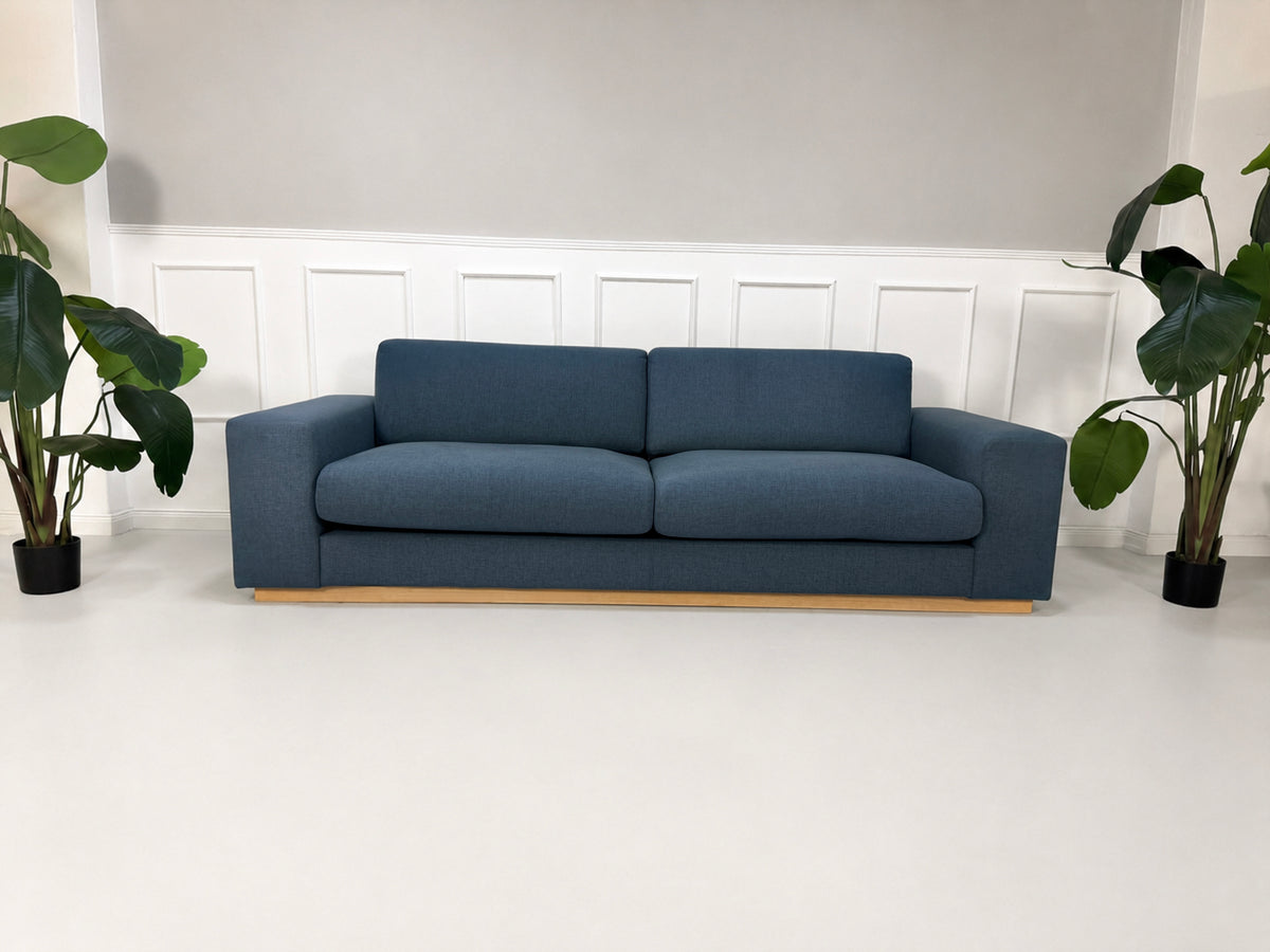 Gebrauchtes blaues Bolia Sepia Designer Stoff Sofa vor einer Wand, stilvoll und modern eingerichtet.