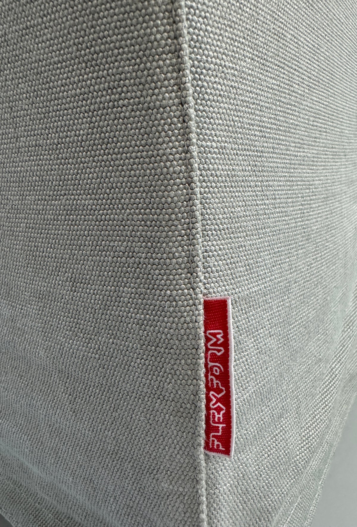 Gebrauchtes graues Flexform Groundpiece Designer Stoff Sofa vor einer Wand, stilvoll und modern eingerichtet.