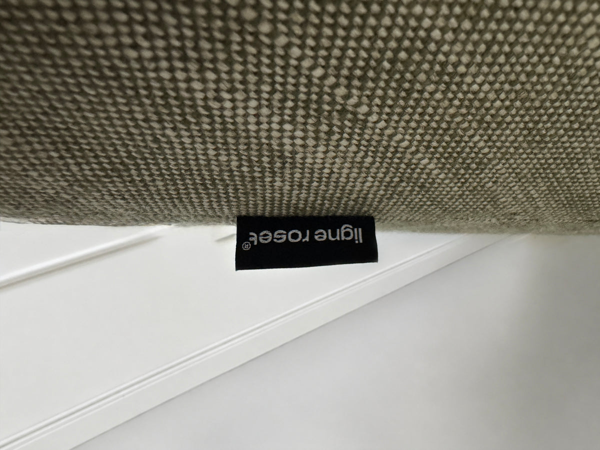 Gebrauchtes graues Ligne Roset Prado Designer Stoff Sofa vor einer Wand, stilvoll und modern eingerichtet.