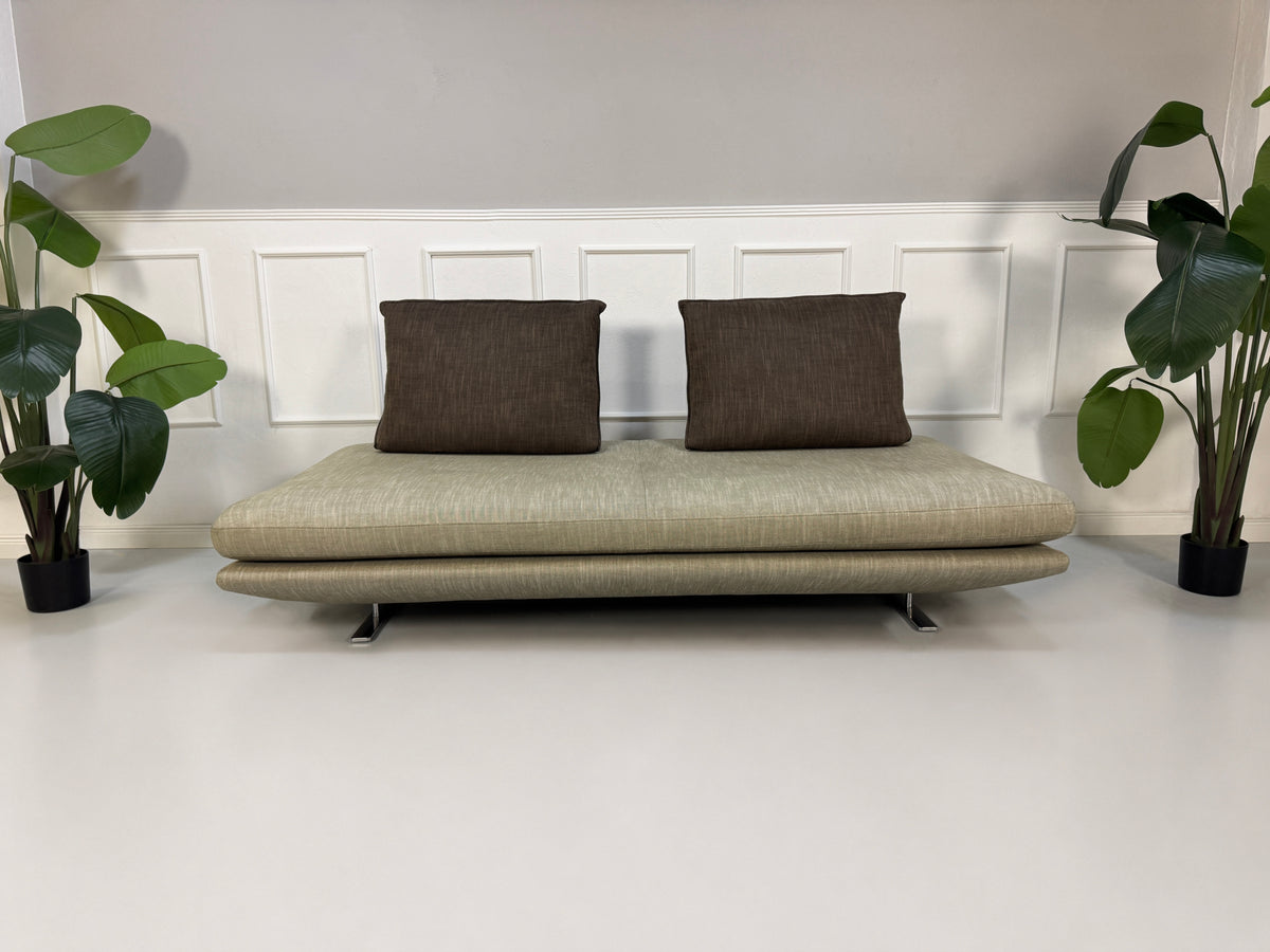 Gebrauchtes graues Ligne Roset Prado Designer Stoff Sofa vor einer Wand, stilvoll und modern eingerichtet.