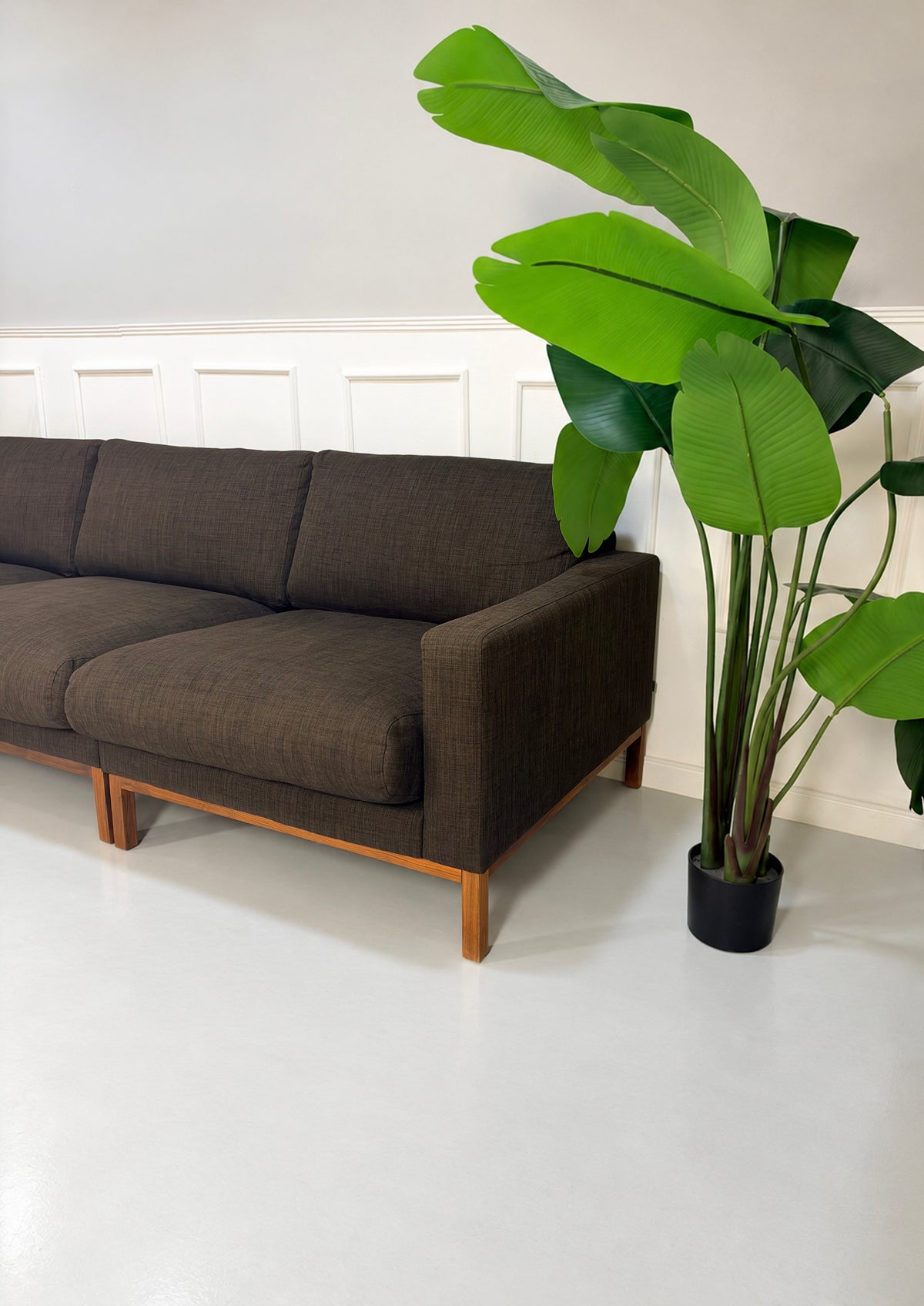 Gebrauchtes braunes Bolia North Designer Stoff Sofa vor einer Wand, stilvoll und modern eingerichtet.