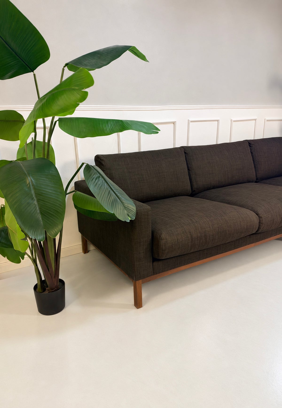 Gebrauchtes braunes Bolia North Designer Stoff Sofa vor einer Wand, stilvoll und modern eingerichtet.